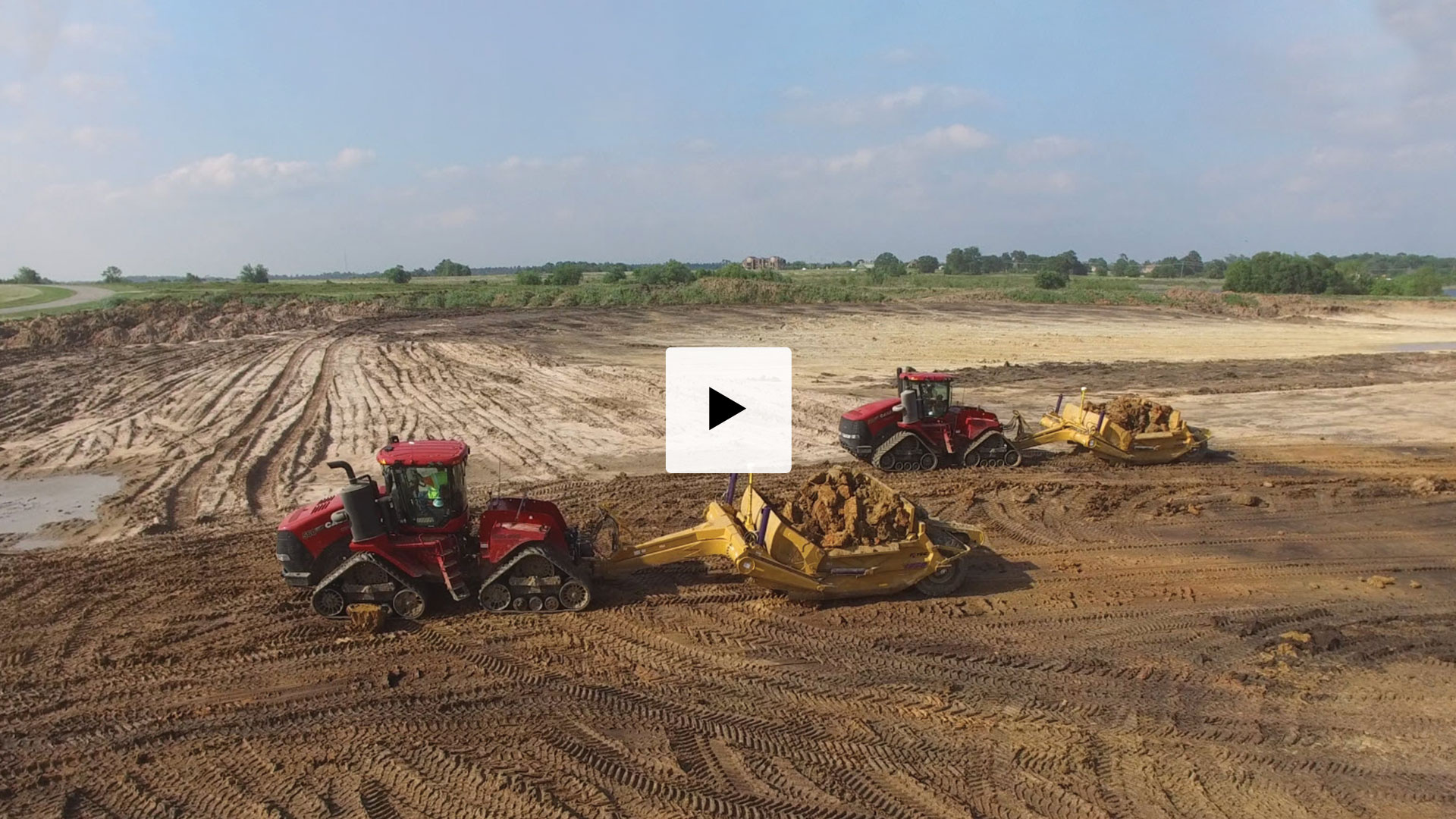 A Versatile 485 tractor pulling a K-Tec 1228 Scraper Pan 