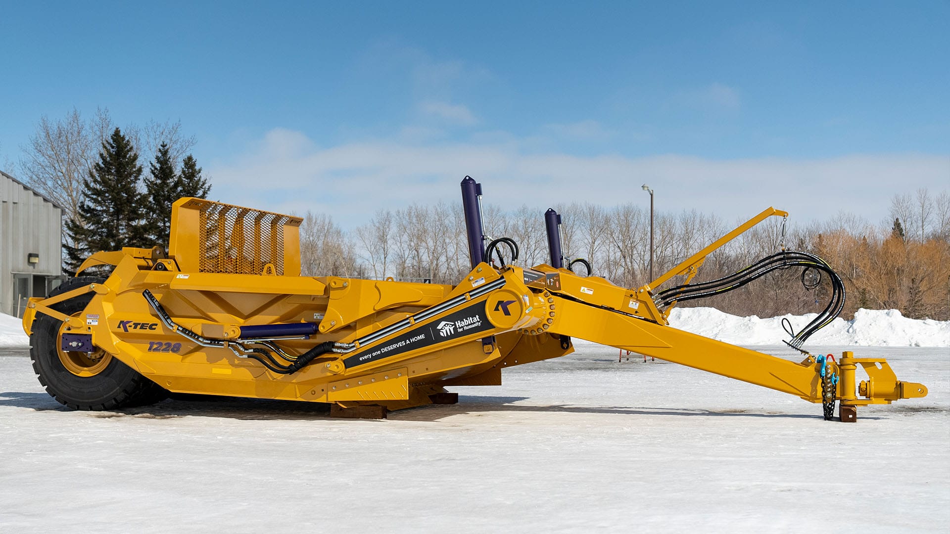 A Versatile 485 tractor pulling a K-Tec 1228 Scraper Pan 